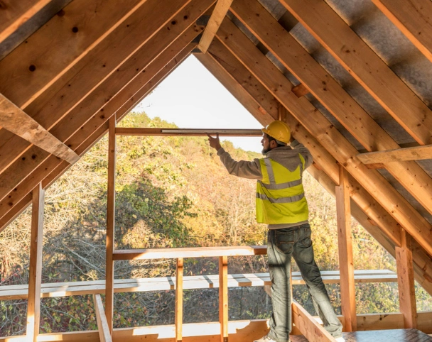 Framing Pro LA carpenter measuring roof framing structure inside residential construction project